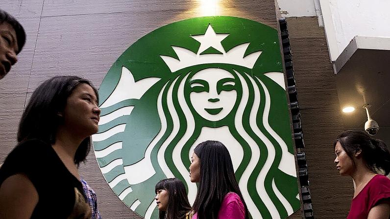 Starbucks vende 60% de sua operação na China à Boyu Capital por US$ 4 bilhões | Pedestres passam em frente a uma loja da Starbucks no distrito de Luohu, em Shenzhen, China. (Foto: Brent Lewin/Bloomberg)