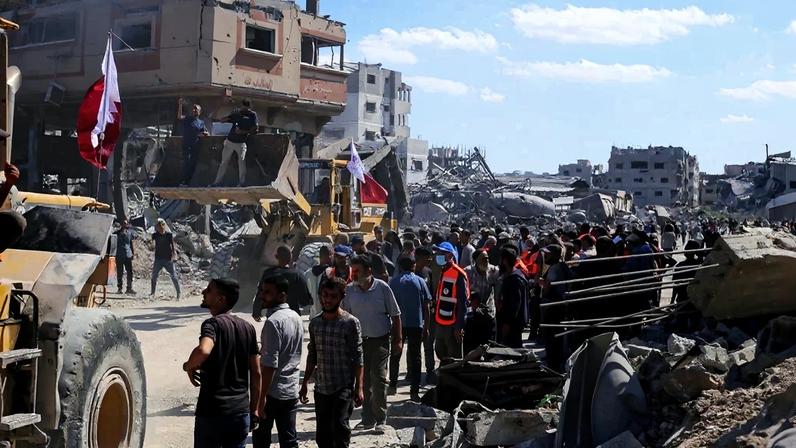Palestinos com escavadeiras tentam limpar os destroços da guerra das ruas de Gaza. Foto: AFP