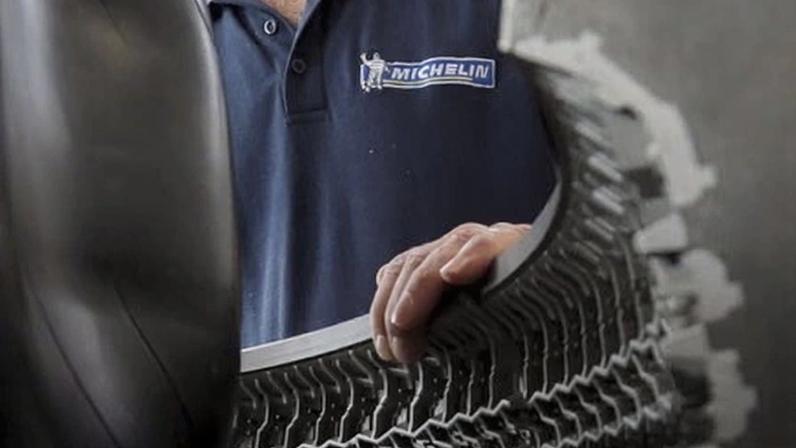 An employee working on a car tyre at the Michelin tyre company's factory in Clermont-Ferrand, France