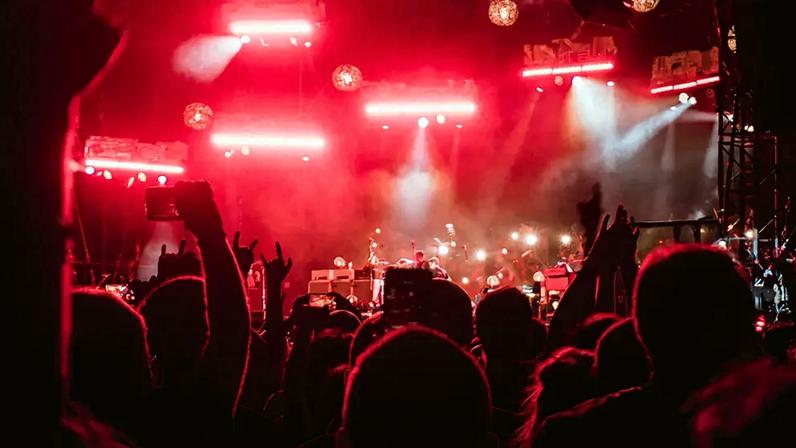 Fotografia de um show com luzes vermelhas.