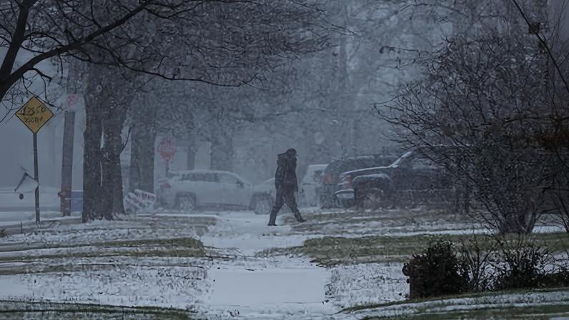 A person walks across the street after a winter storm system hit south-east Michigan, 29 December 2025, in Detroit.