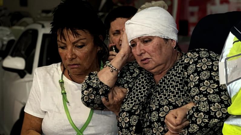 An injured woman makes her way to an ambulance after the shootings at Bondi beach. Photograph: Jessica Hromas/The Guardian