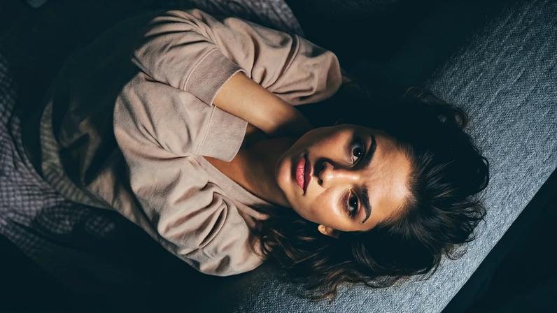 Fotografia de uma mulher com as mãos no rostos triste.