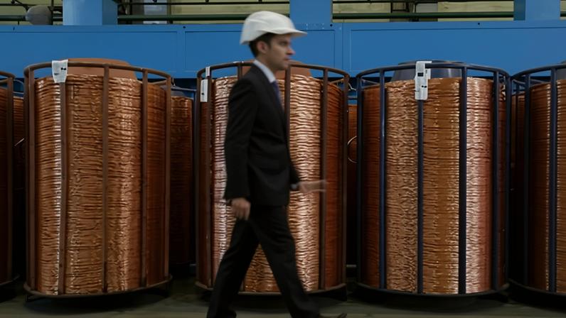 A man walking past rolls of copper rods at a processing plant in Verkhnyaya Pyshma, Russia. The metal has soared by more than 35% in value this year.