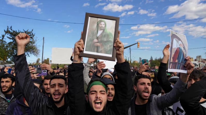 People from the Alawite sect protest as they demand federalism and an end to the killing and violations against Alawites, in Latakia