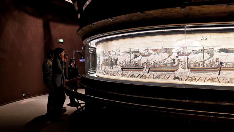 Visitors study the Bayeux Tapestry at the Bayeux Tapestry Museum in Normandy