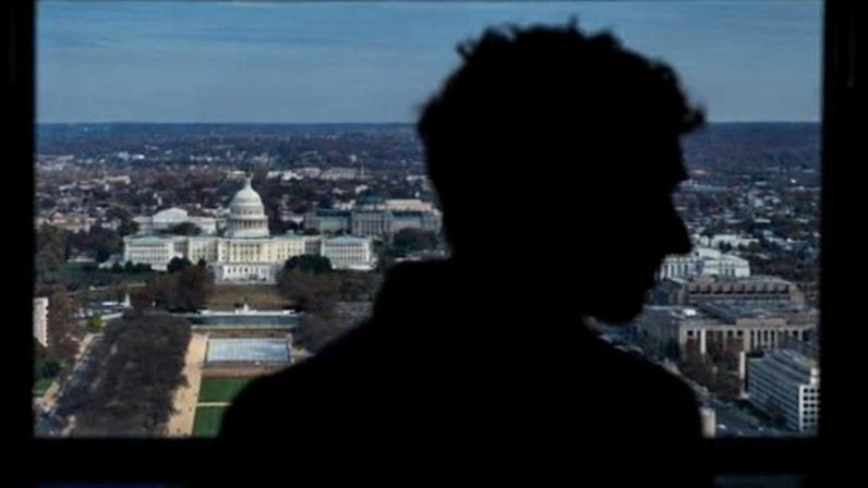 A silhouette and a view of the US Capitol.