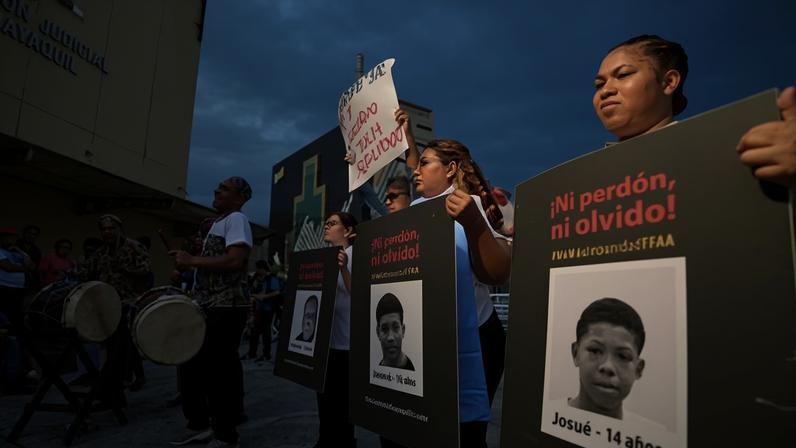 Relatives of the disappeared four and members of human rights organisations hold signs outside a court in Guayaquil on Monday.