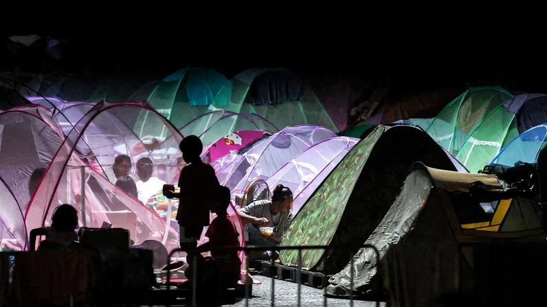 Displaced people gather inside a temporary shelter amid clashes between Thailand and Cambodia along a disputed border area, in Buriram province, Thailand, December 16, 2025. REUTERS/Athit Perawongmetha