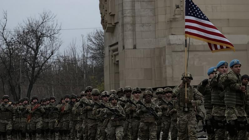 US military march with the US flag during a parade to mark Romania's Great Union Day, in Bucharest, Romania, on 1 December 2025.