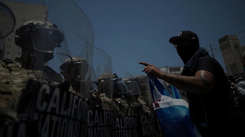 A protester confronts a line of US national guard members in downtown Los Angeles on 8 June 2025.