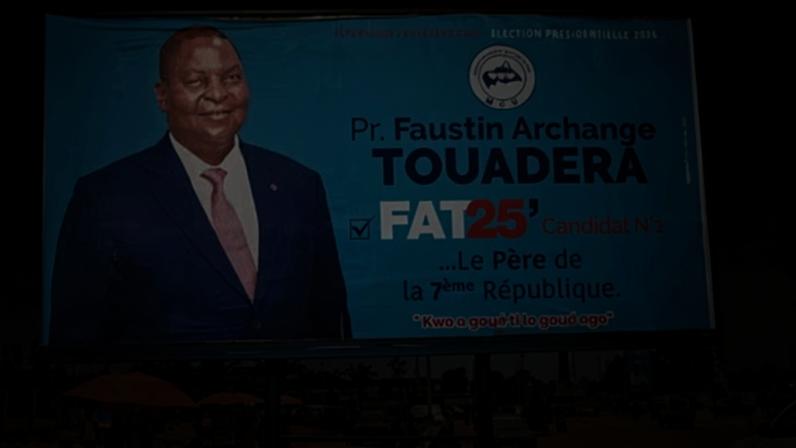 A person rests on a bench under a billboard promoting Faustin-Archange Touadéra’s presidential bid in the capital, Bangui.