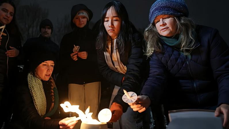 People light their during a vigil at Lippitt Memorial Park on Sunday.