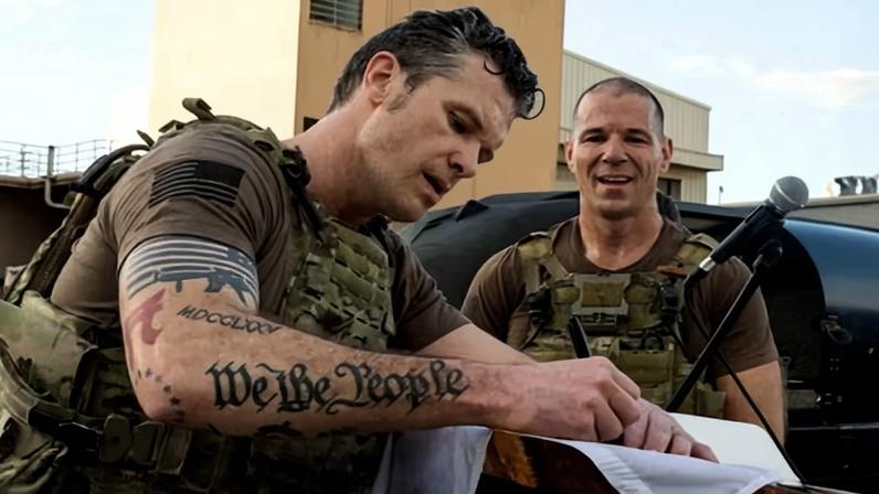 Pete Hegseth signs a flag at a US base in Honolulu, Hawaii, 25 March 2025.
