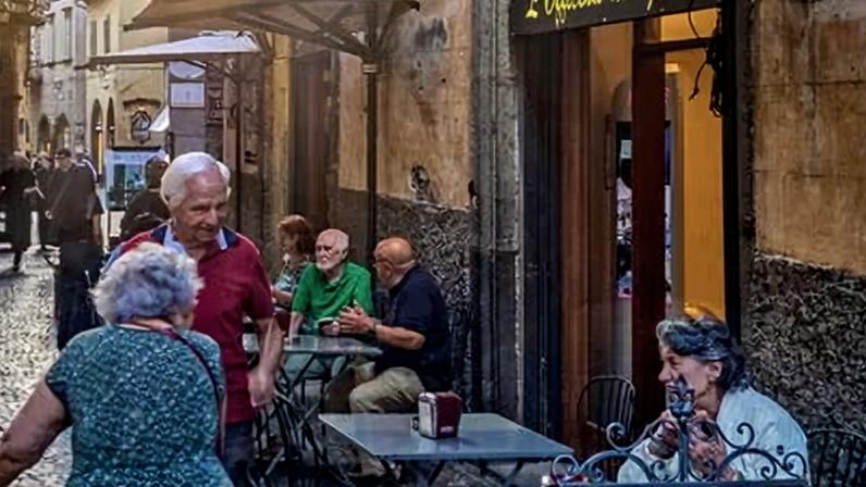 Older people chat outside cafe in Orvieto, Italy. Many say state pension schemes are in trouble.