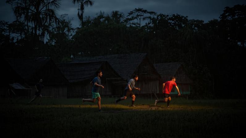 Indigenous youth playing soccer in the rain in northeastern Peru. Image by Gloria Pallares for Mongabay.