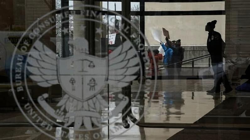 A special police member monitors a protest, while inside the Consumer Financial Protection Bureau (CFPB) building, the day after members of Elon Musk's Doge moved into the CFPB, in Washington DC on 8 February 2025.