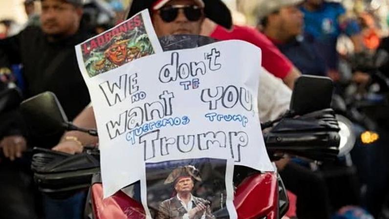 A protestor rides a motorcycle adorned with a poster with the image of Donald Trump, during a rally in Caracas, Venezuela, on 22 December 2025.