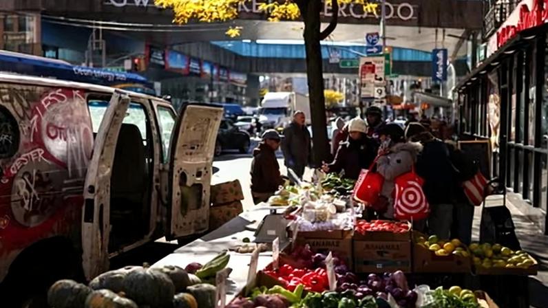People shop for produce at a street vendor stand in the Washington Heights neighborhood of New York City on 4 November 2025.