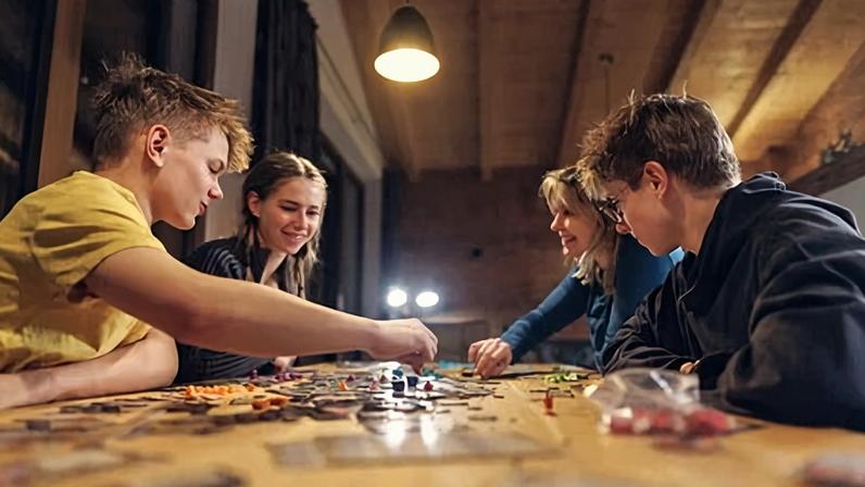 Family playing large modern board game together at home