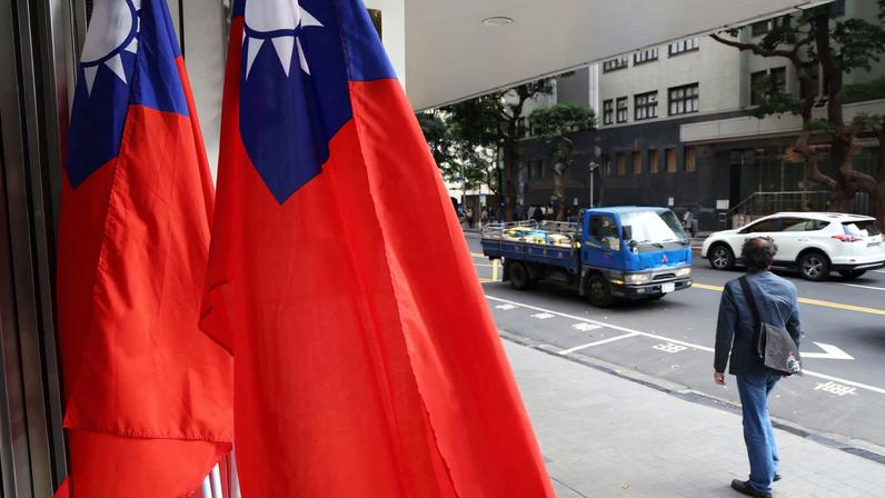 A man walks past Taiwan flags on a street amid China's "Justice Mission 2025" military drills around Taiwan, in Taipei, Taiwan December 29, 2025.