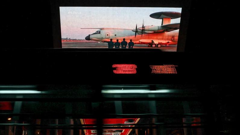 A bus moves past a giant screen showing a news report on China's "Justice Mission 2025" military drills around Taiwan, in Beijing, China December 30, 2025. REUTERS/Tingshu Wang