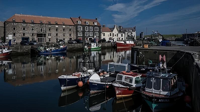 Getty Images Eyemouth harbour with fishing boats in the foreground, buildings in the background and blue skies overhead