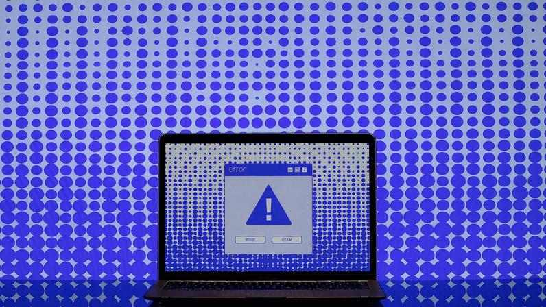 Illustration of a computer screen with a blue exclamation point on it and an error box.