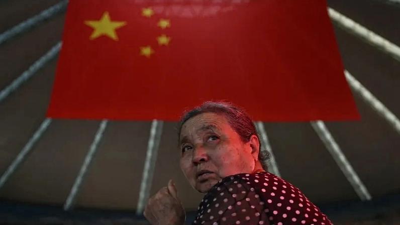 A woman is seen under the Chinese flag at Ordos Airport, in China's northern Inner Mongolia region, on Aug. 14.