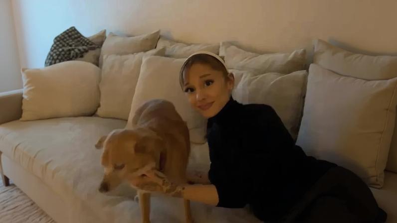 Ariana Grande on a sofa with a dog.