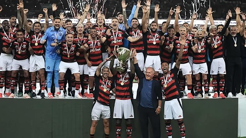 Acompanhados por Zico, De Arrascaeta, Gerson e Bruno Henrique levantam a taça de campeão carioca do Flamengo