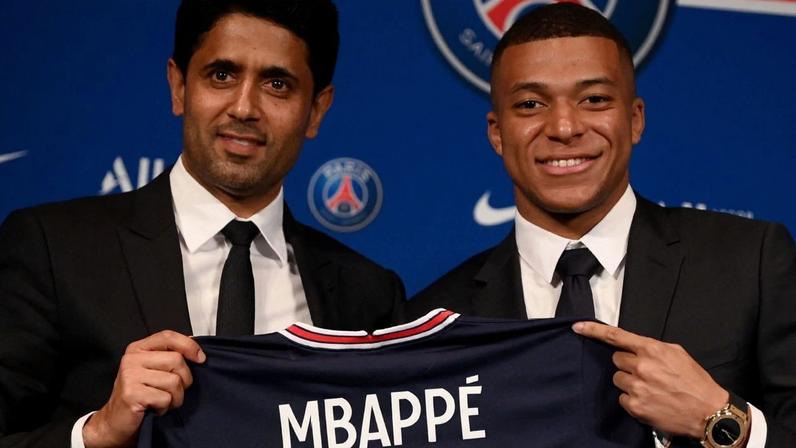 Kylian Mbappé ao lado do presidente do PSG, Nasser Al-Khelaifi, durante coletiva no Parque dos Príncipes, em Paris (FRA) Franck Fife/ Getty Images