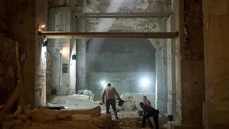 Workers from the Israel Antiquities Authority excavate a section of a city wall from the Hasmonean period in the Old City of Jerusalem.