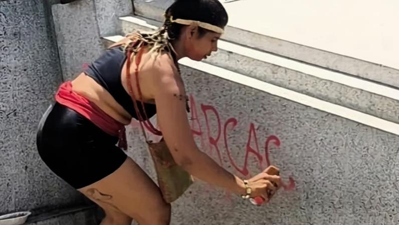 Manifestante de esquerda foi presa após pichar monumento na Praça da Estação, em Minas Gerais (Foto: )