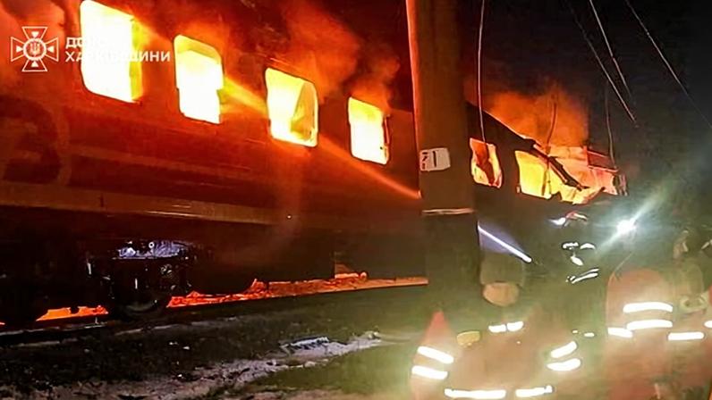 Firefighters attempt to put out fire within a burning passenger train that was hit by Russian drones in the Kharkiv region.