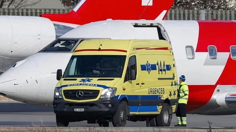 Medical staff work next to Swiss air ambulance planes at Sion airport.