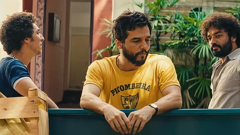 Wagner Moura wears the Pitombeira carnival group’s T-shirt in a scene from The Secret Agent.