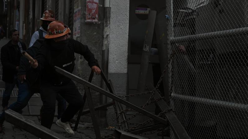 Miners throw objects at police officers blocking access to the government palace as miners affiliated with the Central Obrera Boliviana (COB) take part in a protest against Decree 5503, as diesel and gasoline prices continue to rise, in La Paz, Bolivia, December 30, 2025. REUTERS/Claudia Morales