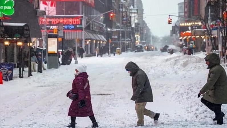 Pedestrians navigate the snow and ice during a winter storm in New York.