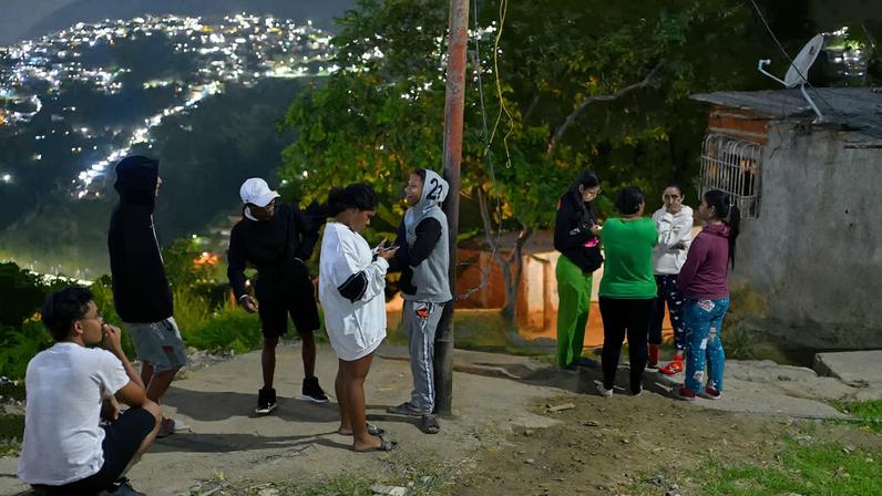 Residents stand in front of their homes in the Gramoven neighborhood, as U.S. President Donald Trump said on Saturday the U.S. has struck Venezuela and captured its President Nicolas Maduro, in Caracas, Venezuela January 3, 2026. REUTERS/Maxwell Briceno