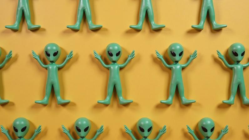 Montagem mostrando diversos aliens, um do lado do outro, num fundo amarelo.