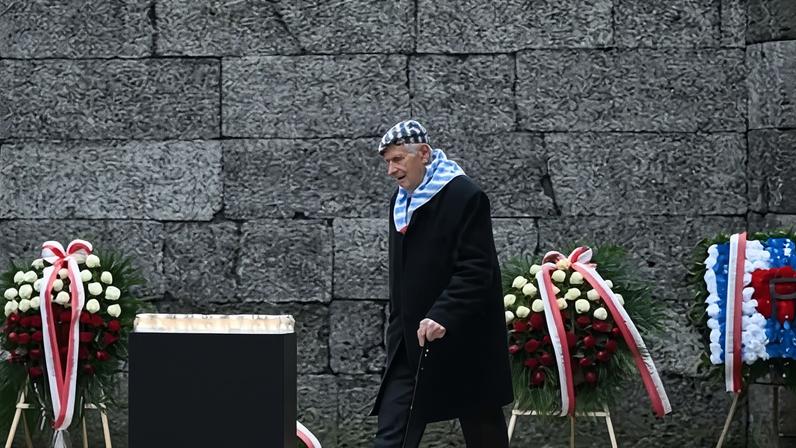 An Auschwitz survivor approaches the Wall of Death, at the former Auschwitz concentration camp where an estimated 1.1 million Jews were killed.