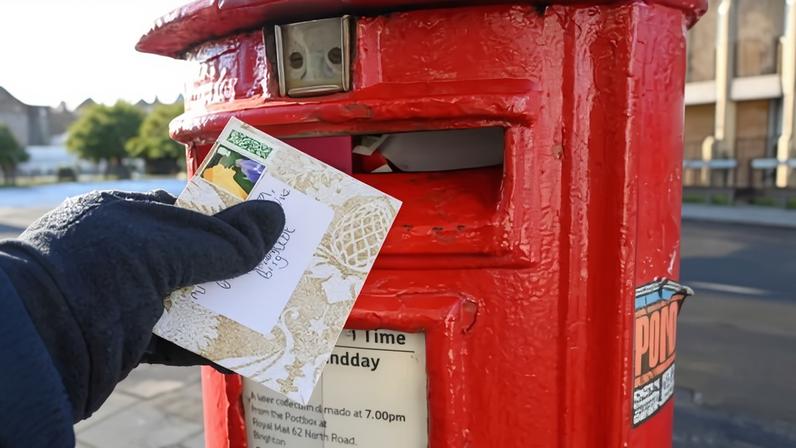 Christmas cards being posted at a postbox.