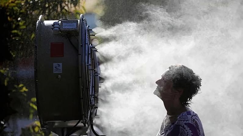 It’s hard to stay cool. A tennis fan stands in front of a mist sprayer during the Australian Open Grand Slam tennis tournament in Melbourne.