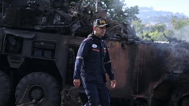 A firefighter surveys the burnt-out wreckage of a military vehicle at La Carlota air base in Caracas on 3 January after US forces attacked.