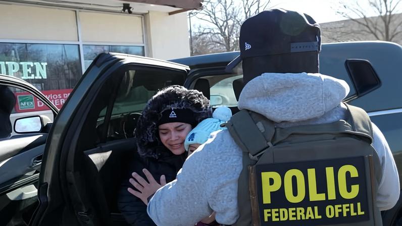 A woman holding a child gets into a federal immigration officer's vehicle on Tuesday in Minneapolis.