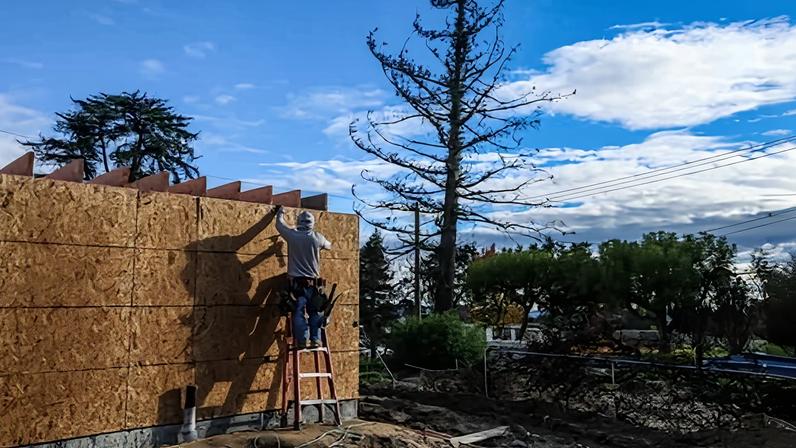 A construction worker works on a home a year after the Eaton fire in Altadena, California, on 6 January.