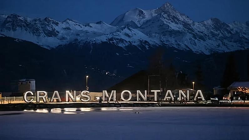 The Crans-Montana sign in front of snow-covered mountains