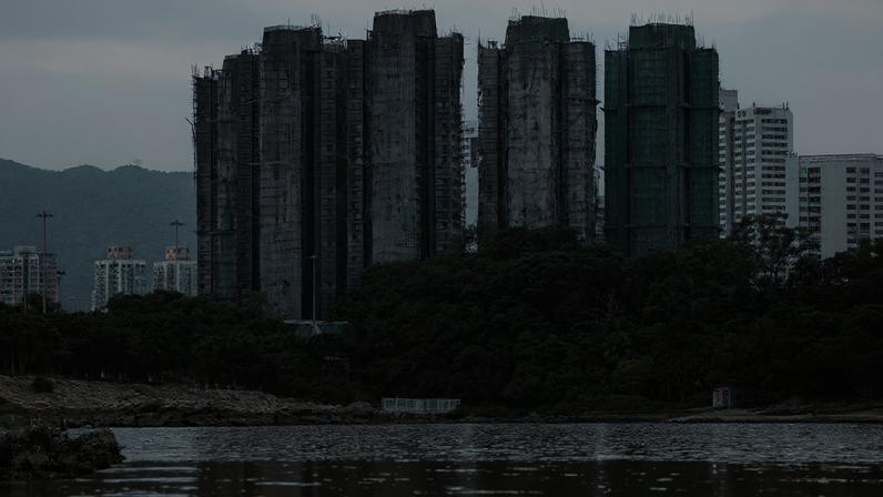 The Wider Image - Hong Kong fire: Echoes of loss below burnt towers