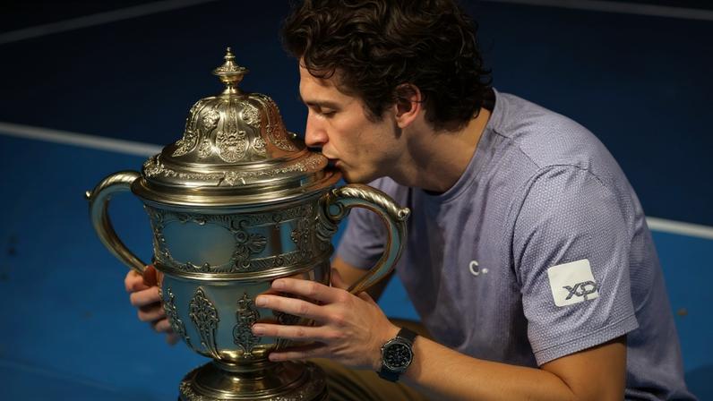 João Fonseca beija o troféu do ATP 500 da Basileia, na Suíça (Foto Fabrice COFFRINI / AFP)